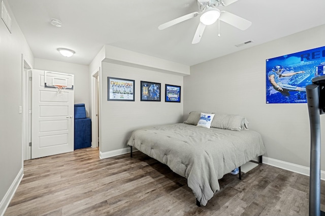 bedroom with visible vents, baseboards, and wood finished floors