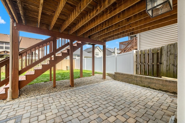 view of patio / terrace featuring stairs, a residential view, and a fenced backyard