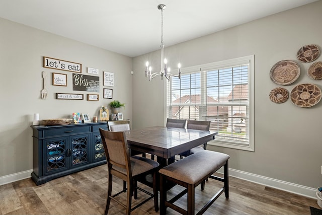 dining room featuring baseboards, an inviting chandelier, and wood finished floors