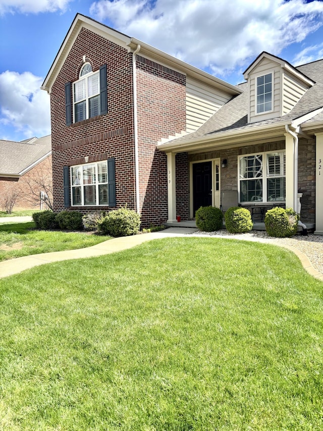 view of front of home featuring brick siding and a front lawn