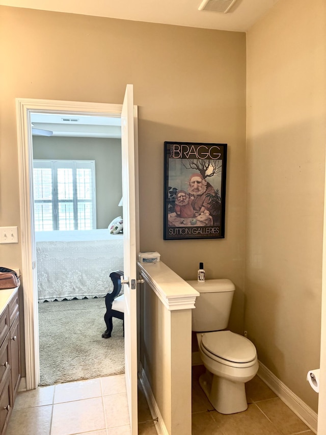 bathroom with vanity, visible vents, toilet, tile patterned floors, and baseboards