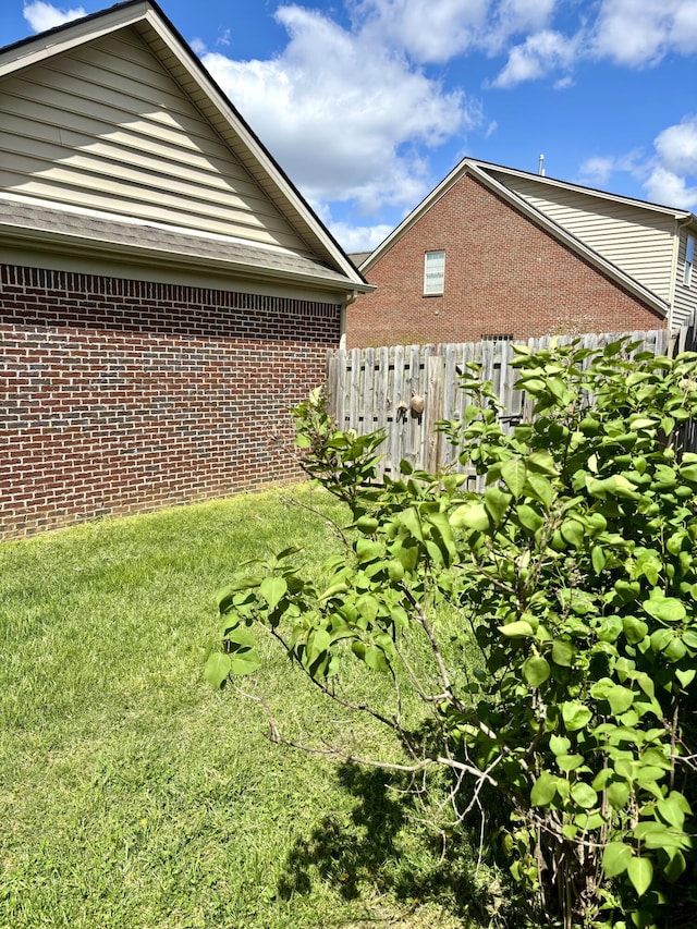 view of side of property featuring brick siding and fence