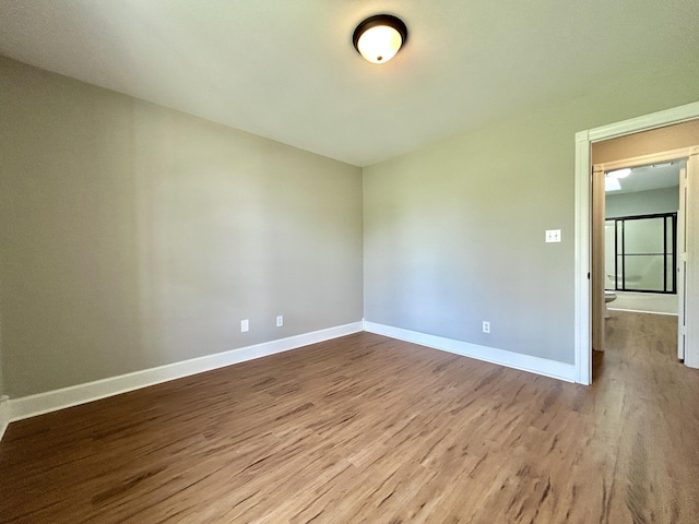 empty room featuring wood finished floors and baseboards