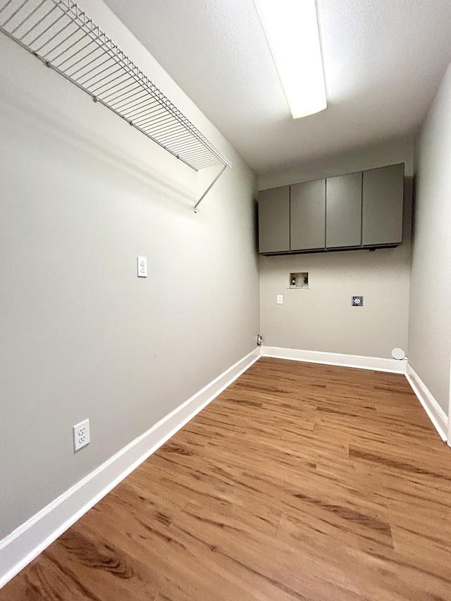 laundry area with light wood-type flooring, baseboards, hookup for a washing machine, and cabinet space