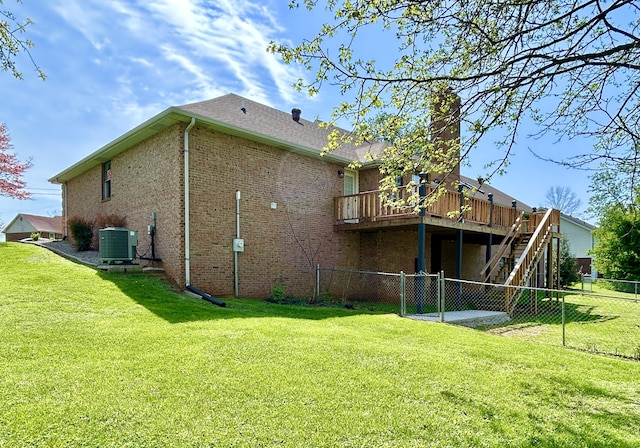 rear view of house with stairway, cooling unit, a deck, fence, and a lawn