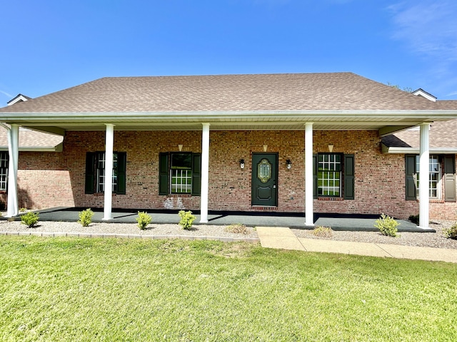 ranch-style home featuring a porch, a front lawn, and brick siding