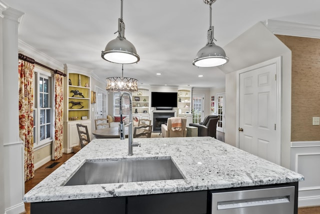 kitchen featuring a healthy amount of sunlight, hanging light fixtures, dishwasher, and a sink