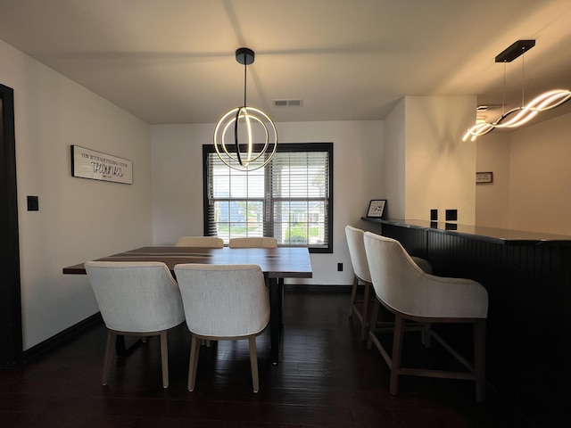 dining space with baseboards, visible vents, dark wood-style floors, and a chandelier