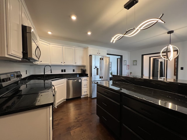 kitchen with dark wood finished floors, white cabinets, hanging light fixtures, and stainless steel appliances