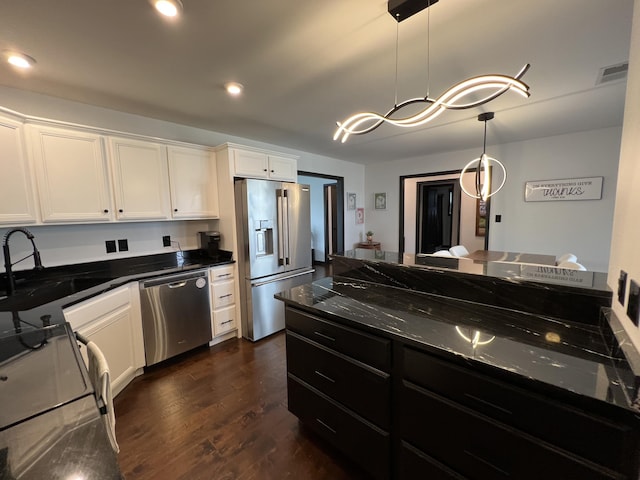 kitchen featuring visible vents, dark wood-style flooring, white cabinetry, a sink, and stainless steel appliances