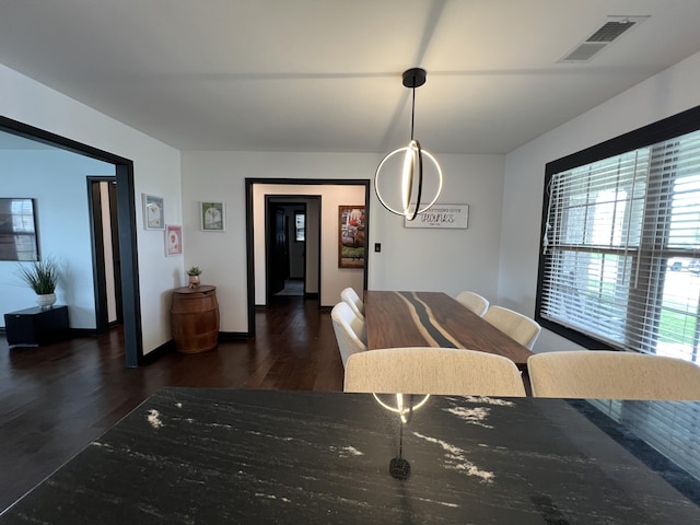 dining area featuring baseboards, wood finished floors, and visible vents