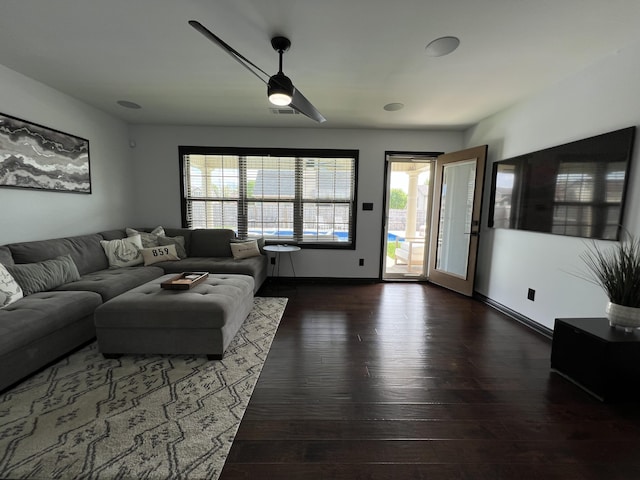 living room with baseboards, visible vents, and hardwood / wood-style floors