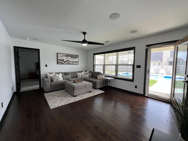 living area with visible vents, dark wood-style flooring, ceiling fan, and baseboards