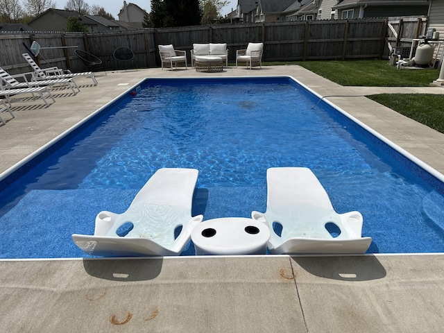 view of swimming pool featuring a fenced backyard, a fenced in pool, a diving board, and a patio
