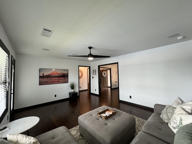 living area featuring visible vents, wood finished floors, a healthy amount of sunlight, baseboards, and a ceiling fan