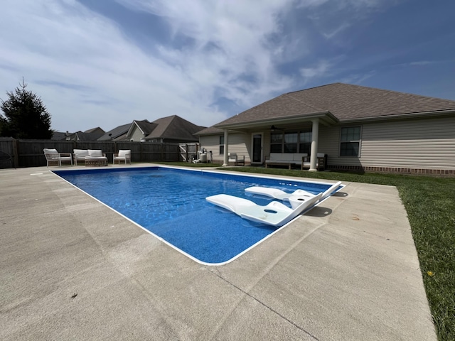 view of swimming pool with ceiling fan, a patio area, a fenced in pool, a fenced backyard, and an outdoor hangout area