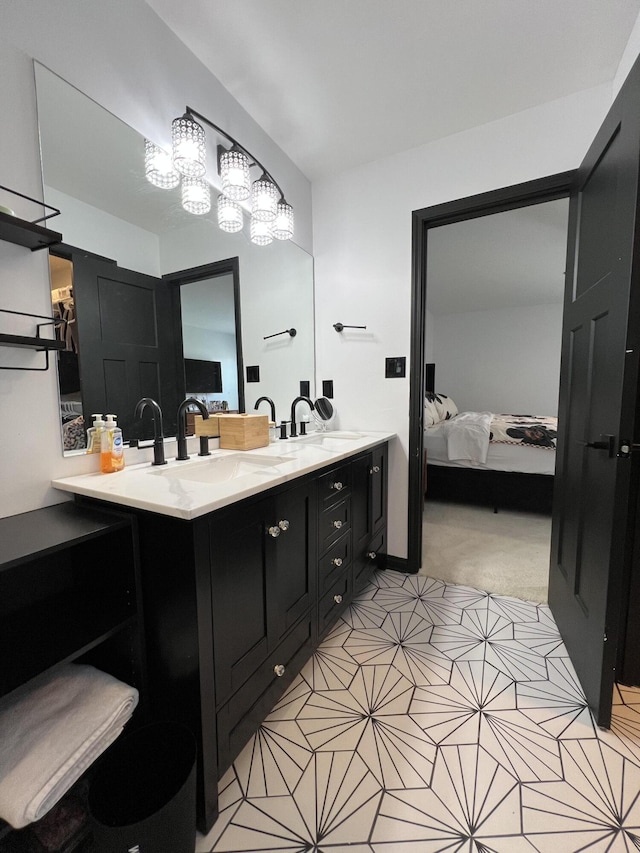 ensuite bathroom with double vanity, tile patterned floors, a sink, and ensuite bath