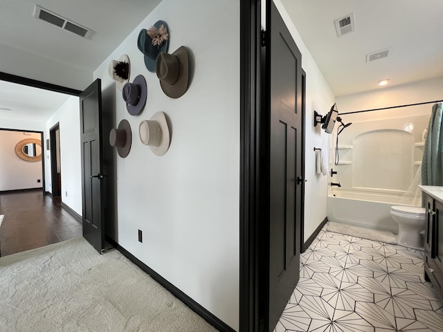 hallway featuring baseboards and visible vents