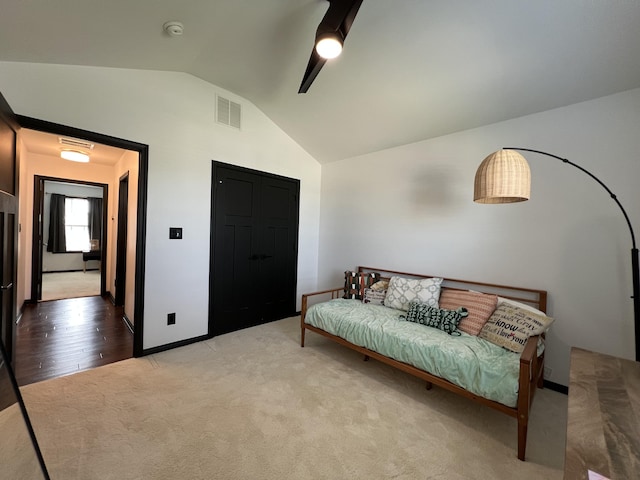 sitting room with visible vents, baseboards, carpet floors, and vaulted ceiling