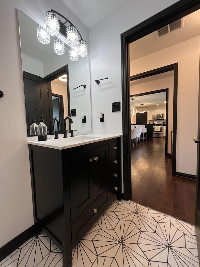 bathroom featuring vanity, visible vents, wood finished floors, and a chandelier
