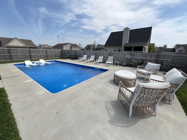 view of swimming pool featuring a patio, a fenced backyard, a residential view, and a fenced in pool