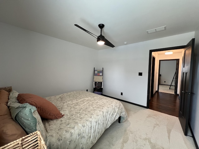 carpeted bedroom with visible vents, baseboards, and ceiling fan