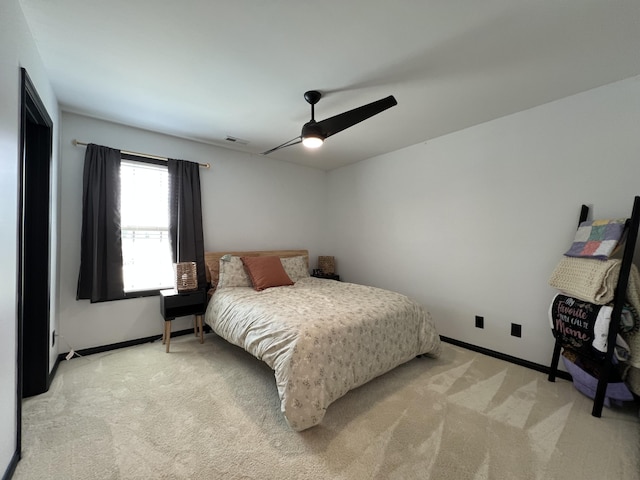 bedroom featuring baseboards, ceiling fan, light carpet, and visible vents