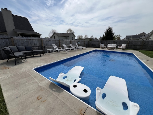 view of pool featuring a fenced in pool, a diving board, outdoor lounge area, and a patio area