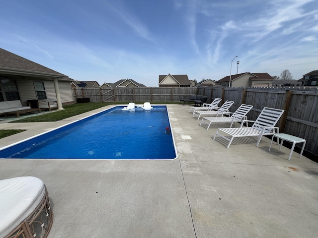view of swimming pool with a fenced in pool, a fenced backyard, and a patio area