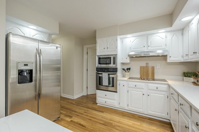 kitchen with light wood-style floors, white cabinetry, appliances with stainless steel finishes, under cabinet range hood, and light countertops