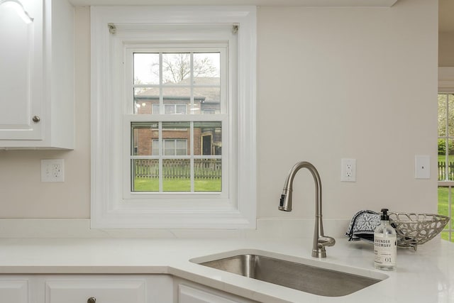 details featuring white cabinets, light countertops, and a sink