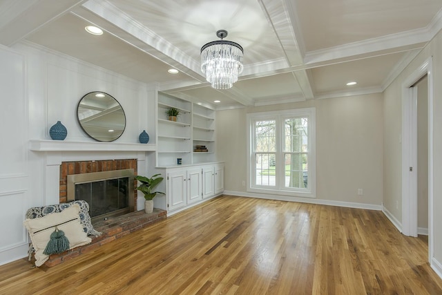 unfurnished living room featuring light wood-style flooring, ornamental molding, baseboards, and a fireplace