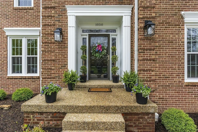 view of exterior entry with brick siding