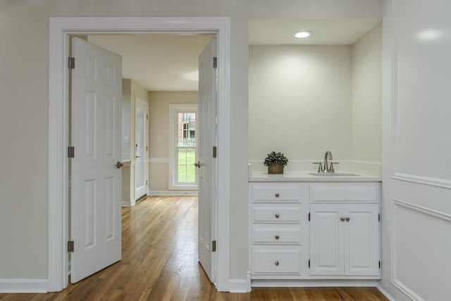 bathroom featuring wood finished floors, vanity, and baseboards