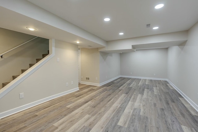 finished below grade area with visible vents, baseboards, and wood finished floors