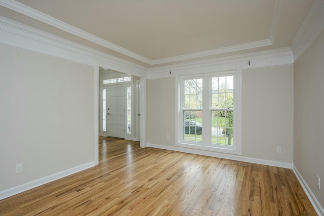 empty room with baseboards, ornamental molding, and wood finished floors