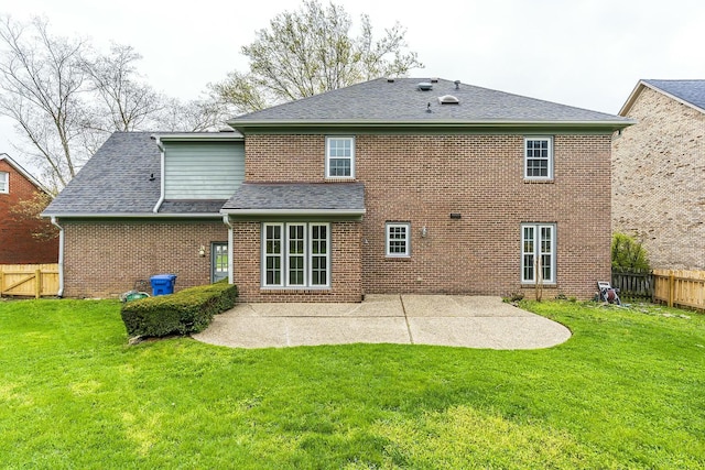 rear view of house with a patio, fence, and a lawn