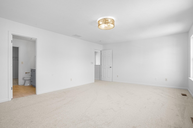 unfurnished bedroom with light colored carpet, baseboards, and visible vents