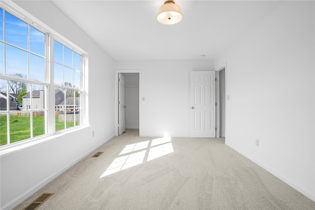 unfurnished bedroom featuring baseboards, carpet flooring, and visible vents