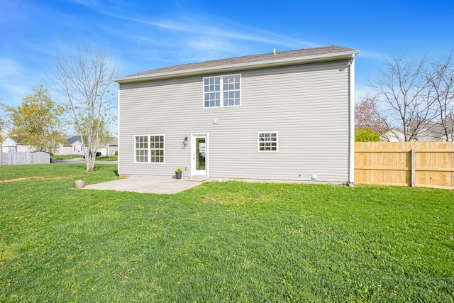rear view of house featuring a patio, fence, and a yard
