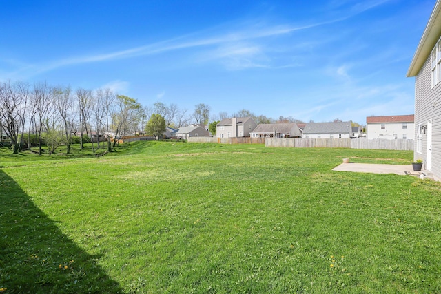 view of yard featuring fence, a residential view, and a patio area