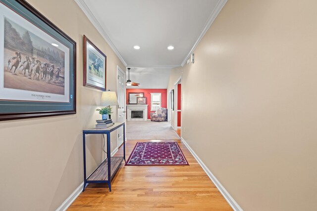 hall with baseboards, crown molding, light wood-type flooring, and recessed lighting