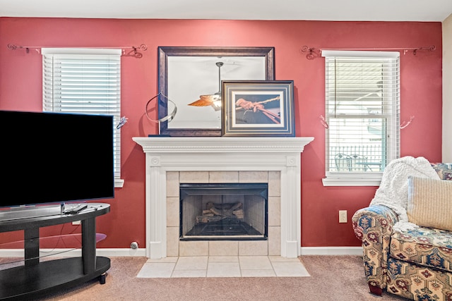 living area with carpet floors, a tile fireplace, and baseboards