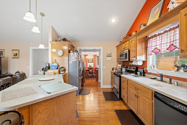 kitchen with a sink, light countertops, lofted ceiling, and stainless steel appliances