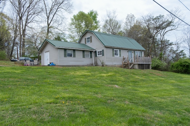 back of house featuring a wooden deck, metal roof, a gambrel roof, and a lawn