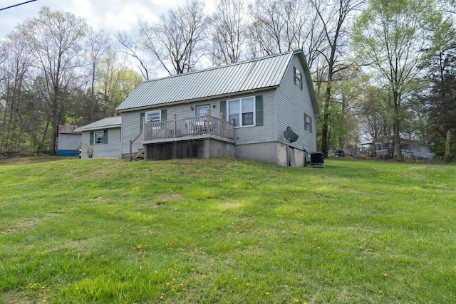 rear view of house featuring a yard, central AC unit, and metal roof