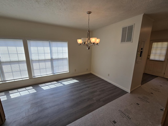 unfurnished dining area featuring visible vents, a textured ceiling, a chandelier, and dark wood finished floors