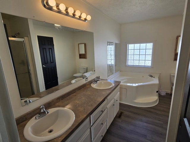 full bathroom with toilet, wood finished floors, and a sink