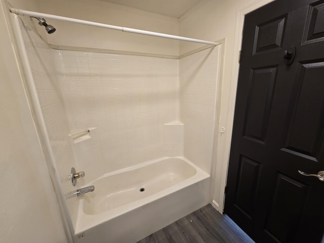 bathroom featuring wood finished floors and  shower combination