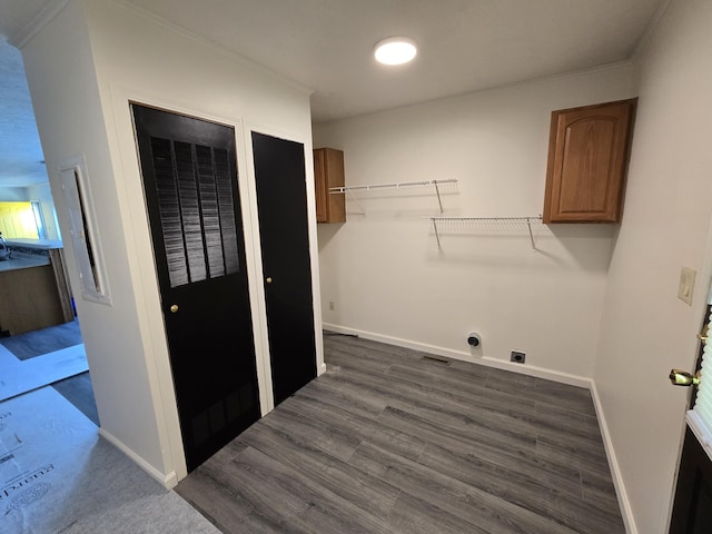 washroom featuring dark wood-style floors, visible vents, hookup for an electric dryer, baseboards, and cabinet space